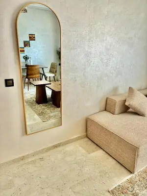 a mirror in a room with a couch and a table at Appartement 2 chambres à Marrakech - Résidence Soulaymane, in Marrakech