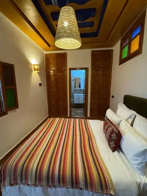 a bedroom with a bed with a colorful blanket on it at Riad Zahri 18 in Marrakech