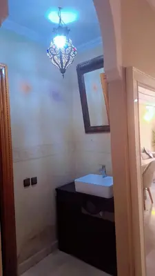 a bathroom with a sink and a chandelier at Appartement Majorella Gueliz in Marrakech