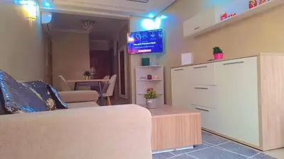 a living room with a couch and a tv on the wall at Appartement Majorella Gueliz in Marrakech