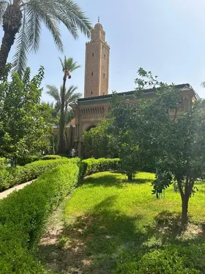 a large building with a clock tower in the distance at Dar Azélia - Charming riad with terrace & pool near Medina in Marrakech