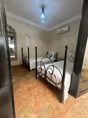 a bedroom with two beds and a mirror at Dar Azélia - Charming riad with terrace & pool near Medina in Marrakech