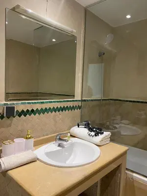 a bathroom sink with a mirror and a shower at studio au centre ville marrakech calme et confort in Marrakech