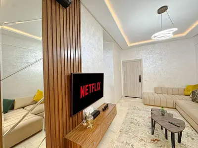 a living room with a television and a couch at Cocon à Marrakech avec balcon in Marrakech