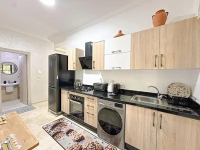 a kitchen with a black refrigerator and a sink at Cocon à Marrakech avec balcon in Marrakech