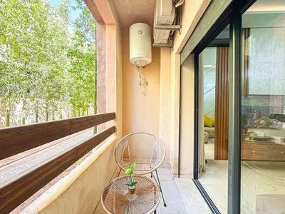 a patio with a chair and a window at Cocon à Marrakech avec balcon in Marrakech