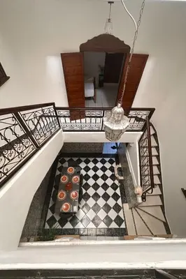 a room with a staircase with a checkerboard floor at Riad Mounad with pool - close to Jemaa el-fna in Marrakech