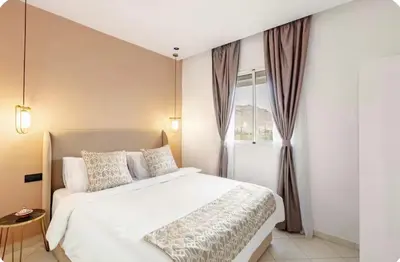 a bedroom with a white bed and a window at Wonderful & Warm in City Center in Oulad Akkou