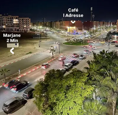 a busy city street at night with cars on the road at Wonderful & Warm in City Center in Oulad Akkou