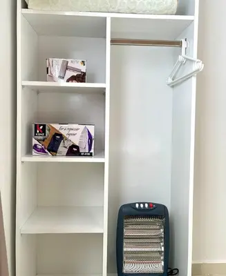 a book shelf with a heater in a closet at Wonderful & Warm in City Center in Oulad Akkou