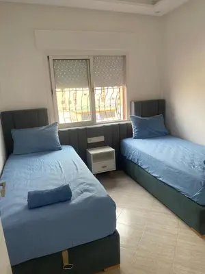 a bedroom with two beds with blue pillows at Apartment Cosy in Marrakech