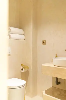 a bathroom with a toilet and a sink and towels at Central apartment plus jacuzzi in Marrakech