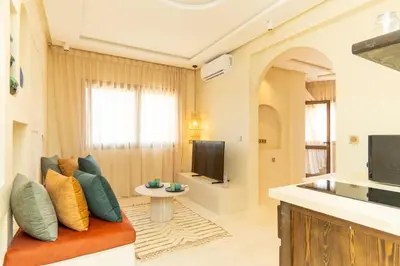 a living room with a couch and a television at Central apartment plus jacuzzi in Marrakech