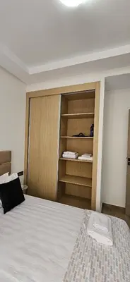 a bedroom with a bed and a wooden closet at Appartement moderne à louer Marrakech in Marrakech