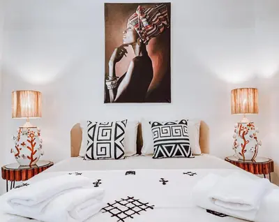 a bedroom with a white bed with two lamps at Riad Sharif in Marrakech