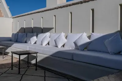 a long blue couch with white pillows on it at Dar Mo'Da in Marrakech