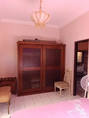 a bedroom with a wooden cabinet and a chair at Riad kech residence al Qarya syahiya Marrakech in Marrakech