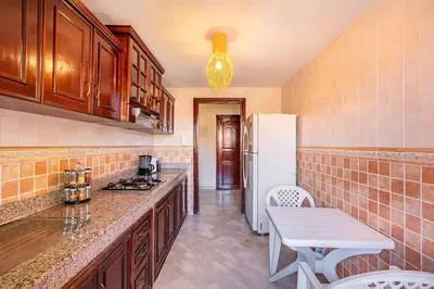 a kitchen with a white refrigerator and a table at Cosy Appartement Rue Loubnane in Marrakech