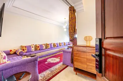 a living room with purple couches and a tv at Cosy Appartement Rue Loubnane in Marrakech