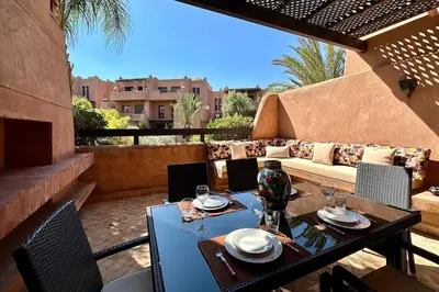 a patio with a couch and a table and chairs at Al Qantara with Terrace and Pool in Marrakech