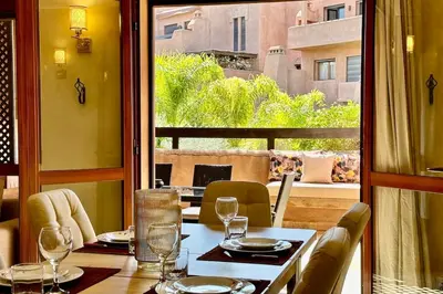 a dining room with a table and a large window at Al Qantara with Terrace and Pool in Marrakech