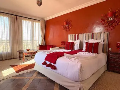 a bedroom with a large bed with red walls at Palais Khemia in Marrakech
