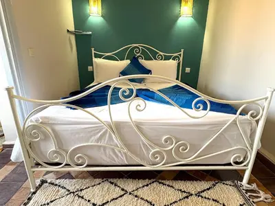 a white bed with blue and white pillows on it at Palais Khemia in Marrakech