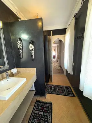 a bathroom with a sink and a mirror and a hallway at Palais Khemia in Marrakech