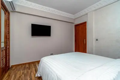 a bedroom with a bed and a tv on the wall at Yaza appartement in Marrakech