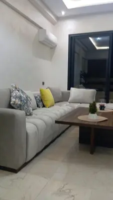 a living room with a couch and a coffee table at Charmant appartement au coeur de Guéliz à côté de train in Marrakech