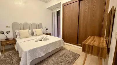 a bedroom with a large bed with a white bedspread at Premium Village, appartement cosy in Marrakech