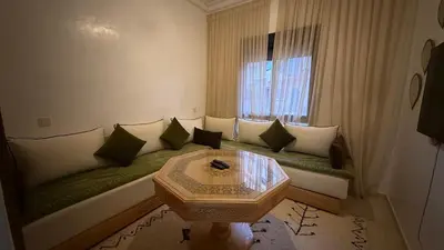 a living room with a couch and a table at Premium Village, appartement cosy in Marrakech