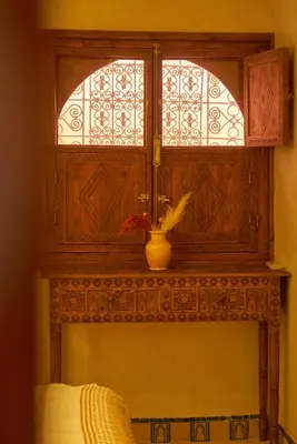 a window in a room with a vase on a mantle at Taj Riad Zitoune in Marrakech