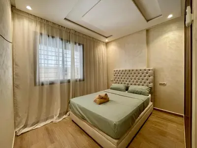 a bedroom with a bed with a dog laying on it at Burj Malak Comfort and Pool in Marrakech