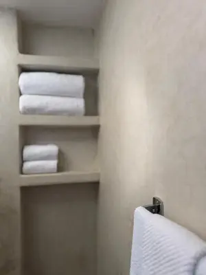 a bathroom with towels on shelves in a room at Stylish YSL Street 2-BDR, parking, hi speed wifi in Marrakech