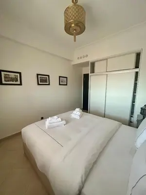 a bedroom with a large white bed with towels on it at Appartement moderne 2 chambres proche Gueliz in Marrakech
