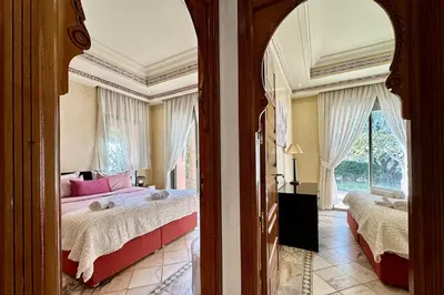 a bedroom with two beds and a large window at Sunny apartment in Palmeraie with Pools and Gardens in Marrakech