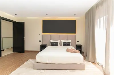 a bedroom with a large white bed with a large headboard at Villa NAYA in Marrakech