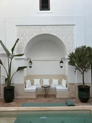 a living room with a white couch next to a pool at Riad Elena l Private Riad with heated Pool in Marrakech l 3 rooms in Marrakech