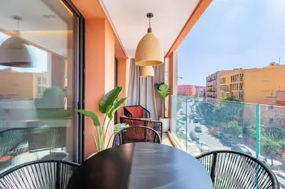 a table and chairs on a balcony with a view of a street at Luxury apartment near to McDonald's in Marrakech