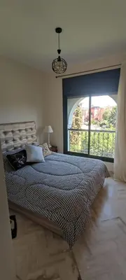 a bedroom with a large bed with a large window at Atlas Golf Resort - Marrakech palmeraie a 6 k m du centre in El Mgassem