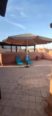 two chairs and an umbrella on a roof at Atlas Golf Resort - Marrakech palmeraie a 6 k m du centre in El Mgassem
