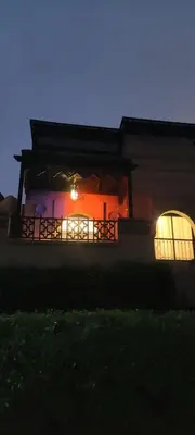a house lit up at night with a balcony at Atlas Golf Resort - Marrakech palmeraie a 6 k m du centre in El Mgassem