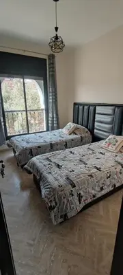 two beds sitting in a room with a window at Atlas Golf Resort - Marrakech palmeraie a 6 k m du centre in El Mgassem