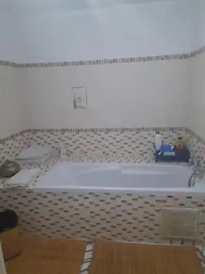 a bath tub in a bathroom with a tiled floor at Marrakech en toute simplicité in Marrakech