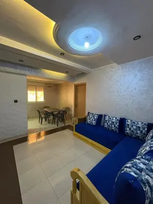a living room with a blue couch and a table at Appartement 85m dans un quartier calme in Marrakech