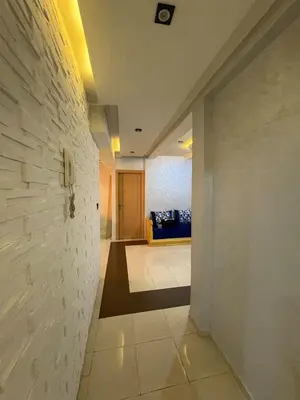 a hallway with a white wall and a yellow couch at Appartement 85m dans un quartier calme in Marrakech