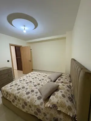 a bedroom with a bed with a flowery comforter at Appartement 85m dans un quartier calme in Marrakech