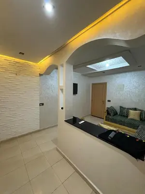a living room with a couch and a bed at Appartement 85m dans un quartier calme in Marrakech
