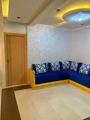a blue couch in the corner of a room at Appartement 85m dans un quartier calme in Marrakech